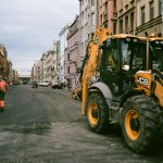 people and construction truck on a street between buildings